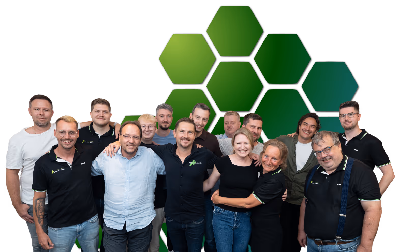 Gruppenfoto von 15 Personen, die lächeln und sich vor einem grünen sechseckigen Muster umarmen.