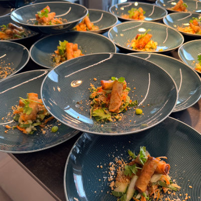 Drei Männer besprechen Dokumente auf einem Tisch in einem hellen Büro.