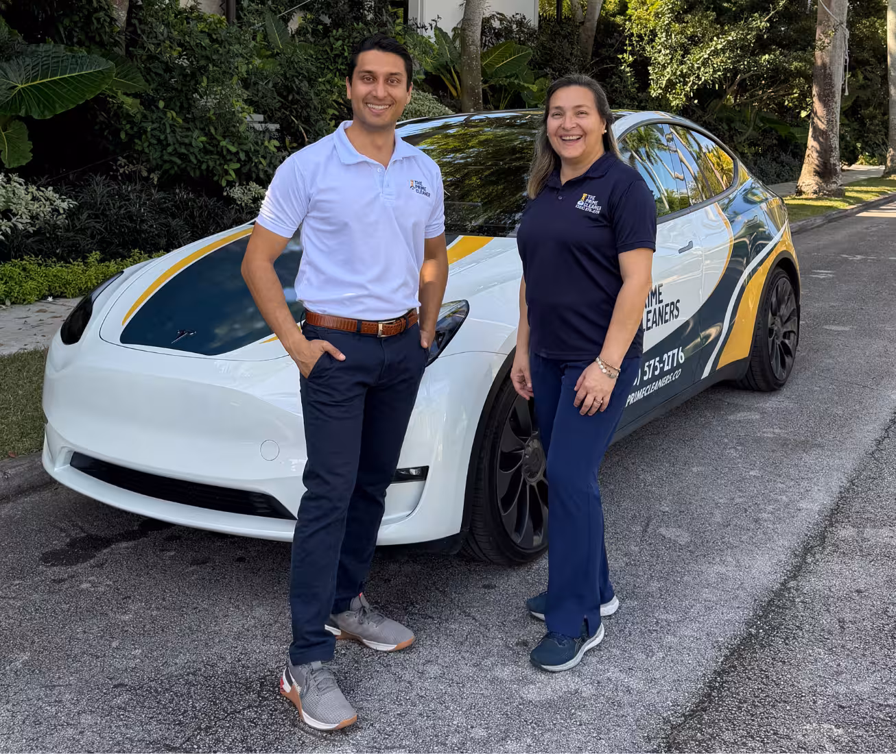 Ana and Jay co-owners posing in front of wrapped Tesla Model Y