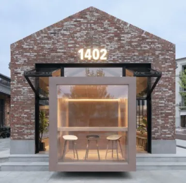 A brick building with a lit up bar in front of it.