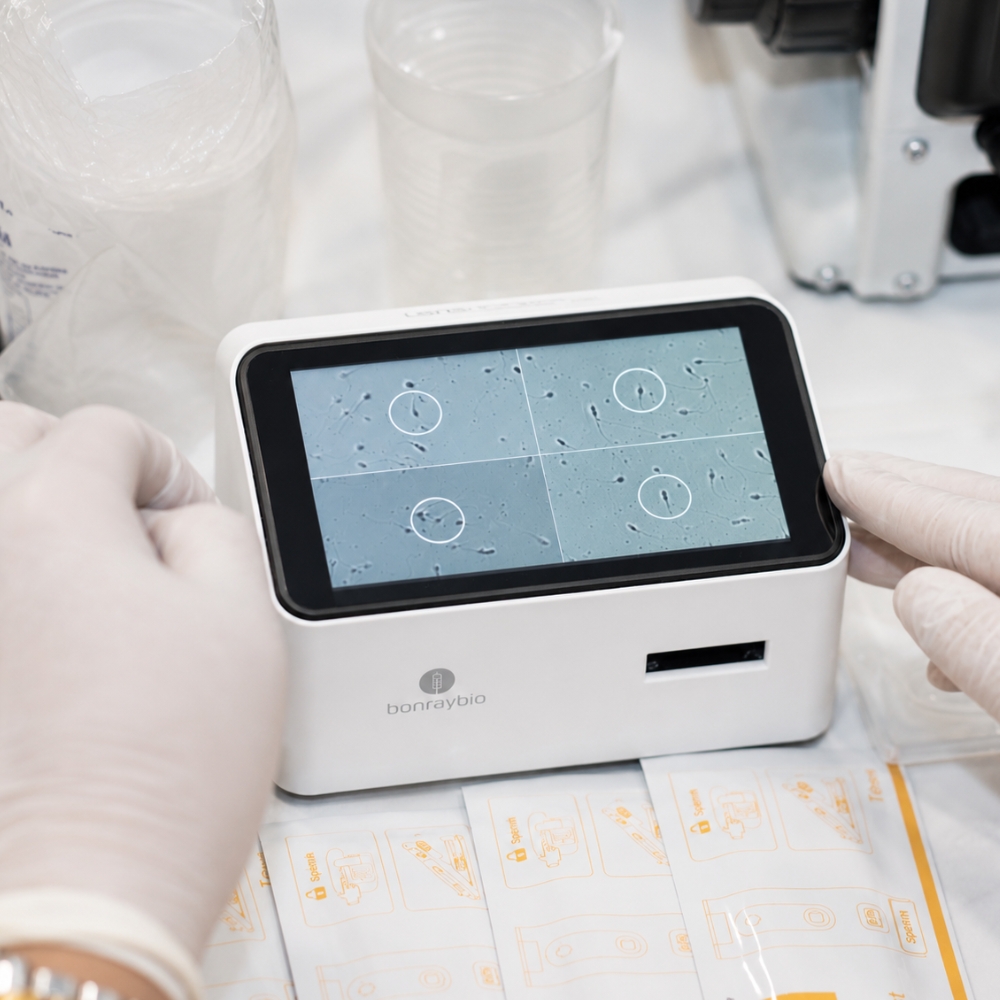 Laboratory technician reviewing sperm cells on a digital semen analysis device.