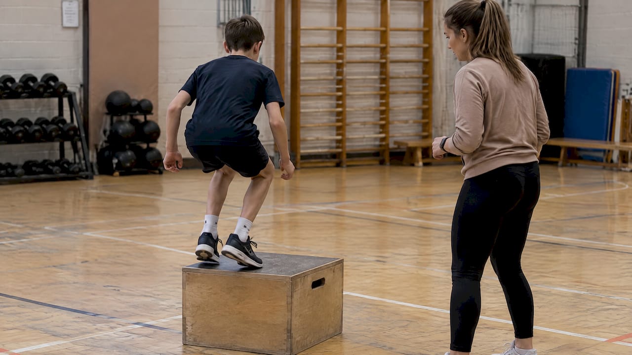 Young athlete practising supervised landing drills