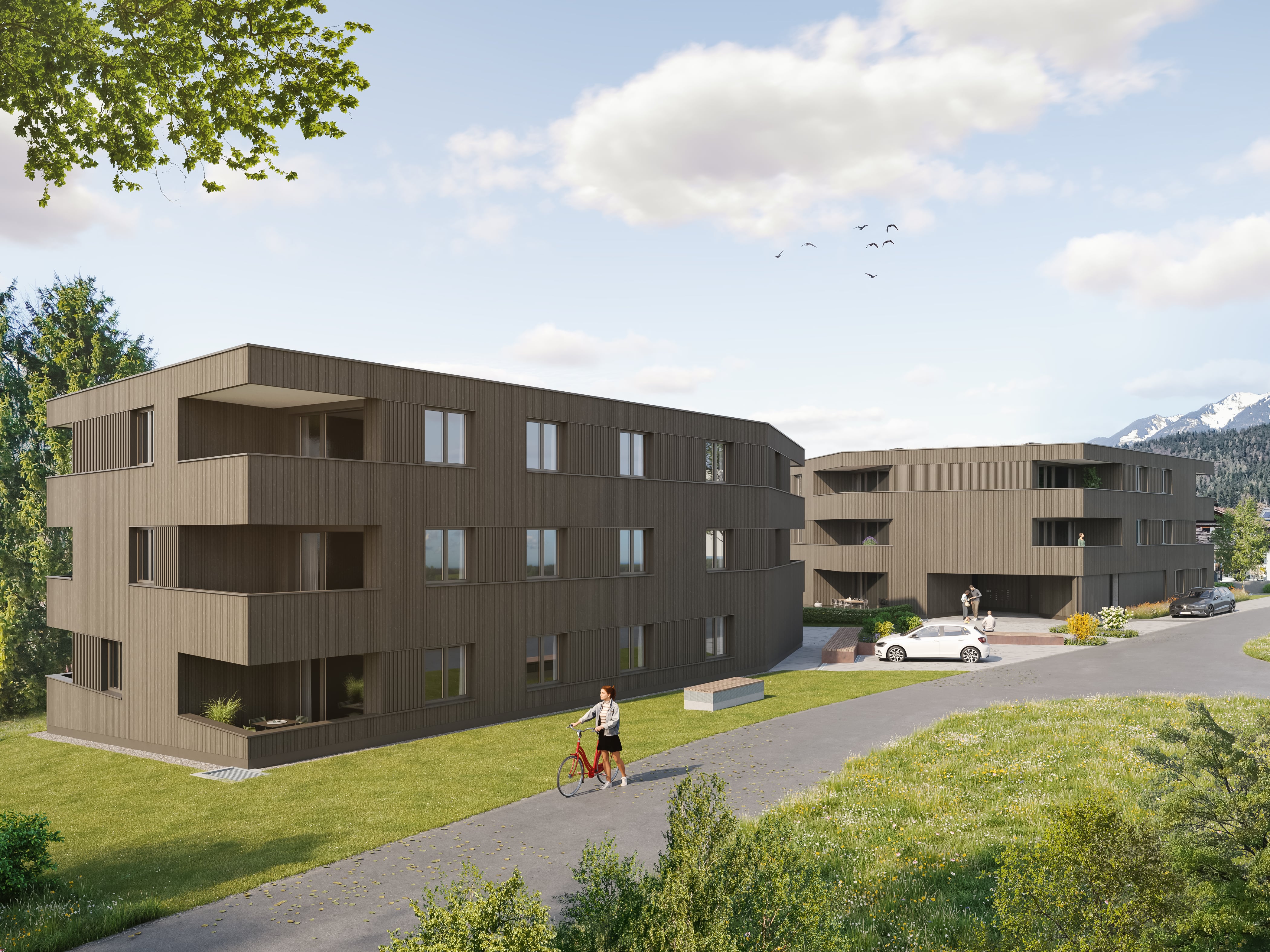 Two modern three-story brown buildings near grassy area with person walking a bike on path.