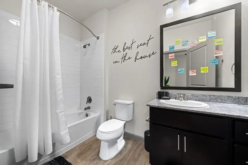 Stylish bathroom with a vanity, toilet, and shower/tub combination featuring subway tile, showcasing apartment finishes at Altitude in Houston, TX.