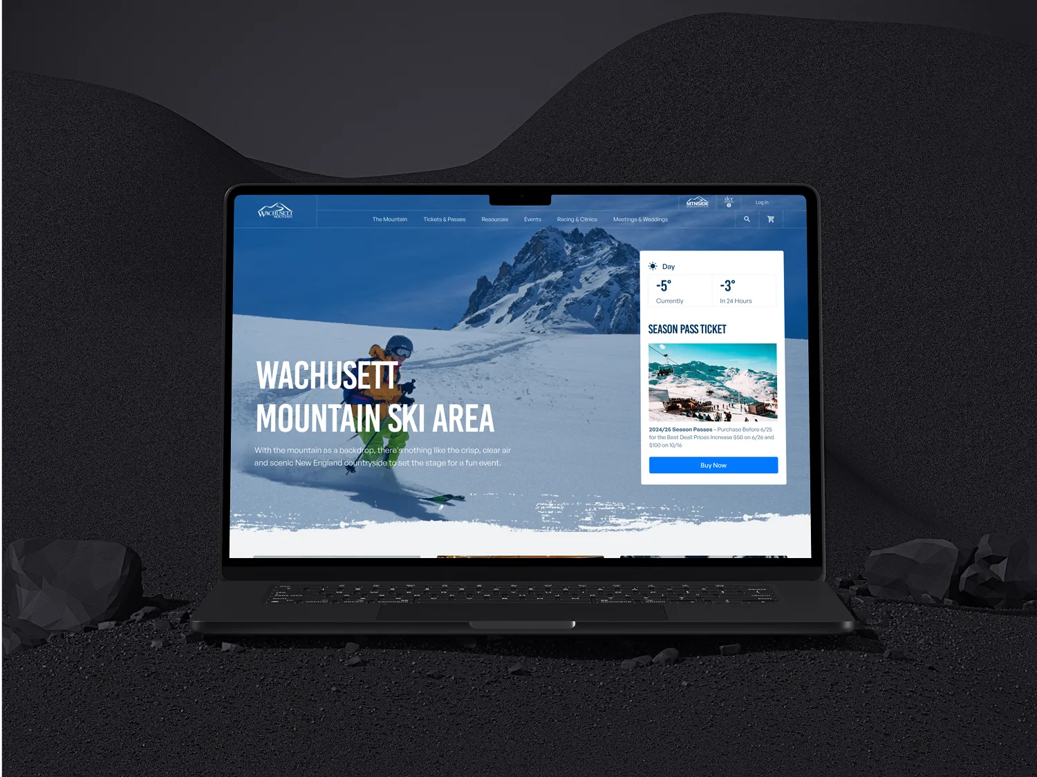 A laptop displaying a website about a ski area, featuring a background image of snow-covered mountains and a person skiing.