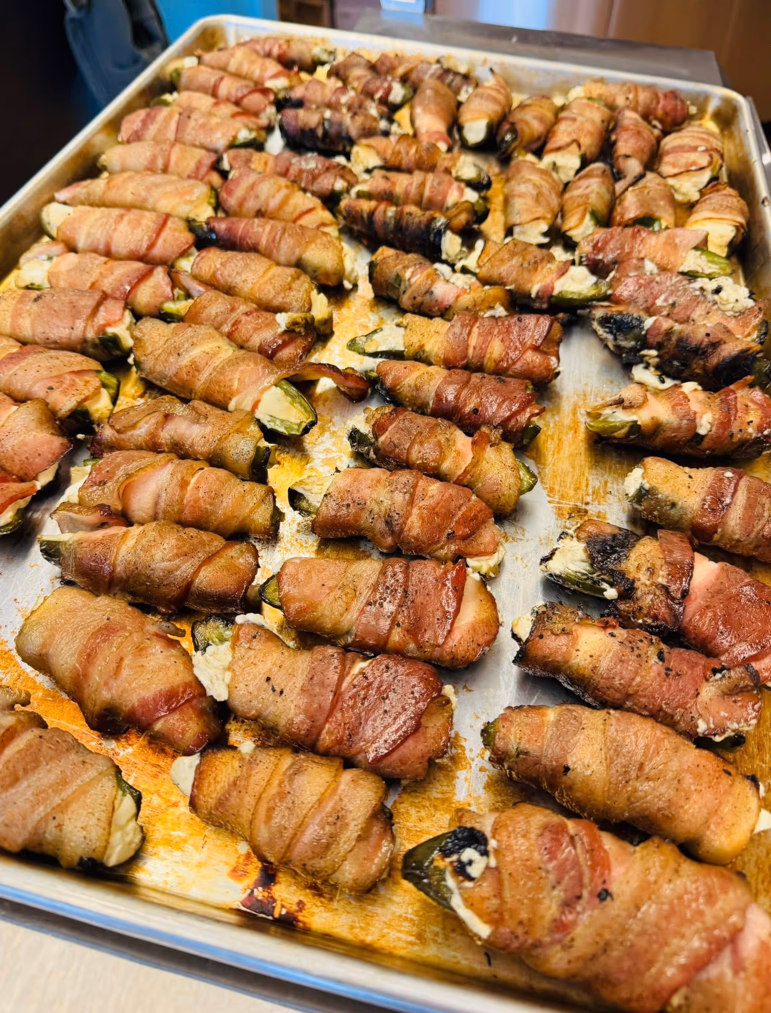 tray of jalapenos stuffed with cream cheese and wrapped in bacon