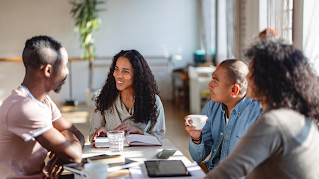 B2B team meeting around a table with notebooks, tablets, and coffee cups