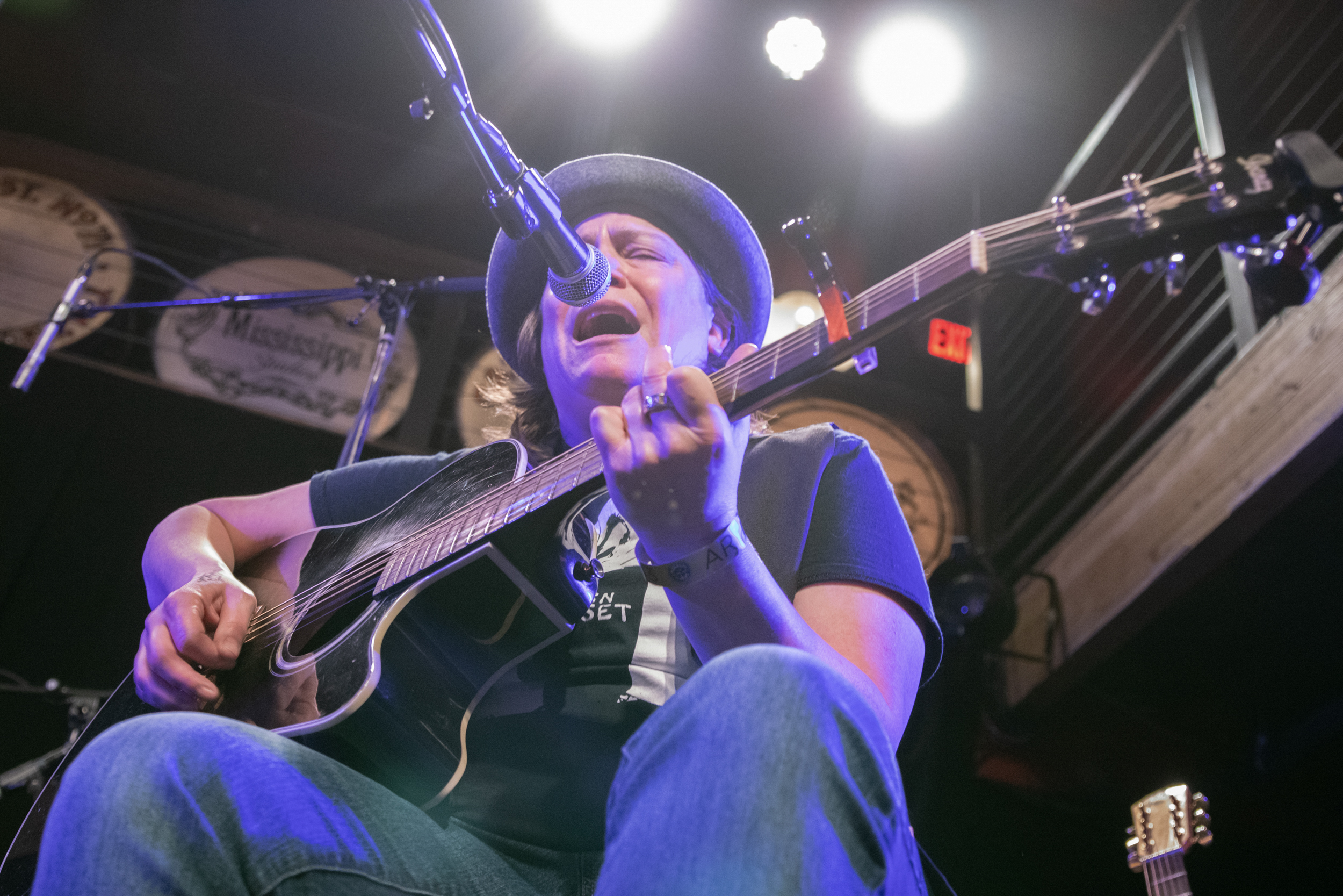 Close up image of Annie singing with guitar on her lap