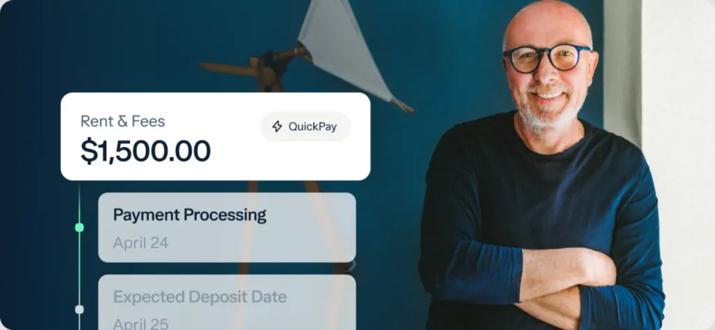 A smiling man with glasses and a beard stands with arms crossed in front of a blue wall. On the left, a digital display highlights "Rent & Fees $1,500.00" with QuickPay—an easy way to track payments from your business vs personal bank account.