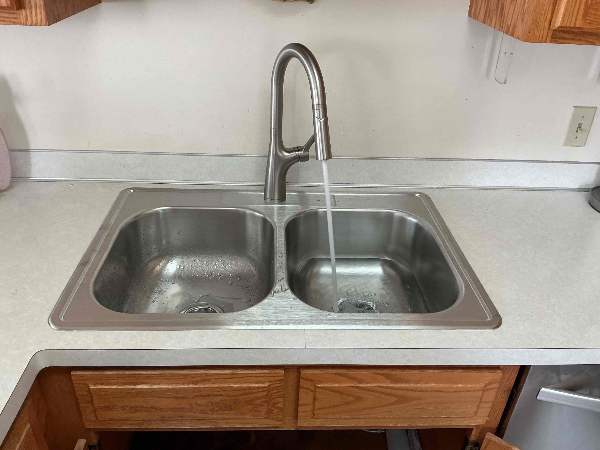 The new faucet running. Testing a new kitchen faucet for leaks after installation in Eagan Minnesota