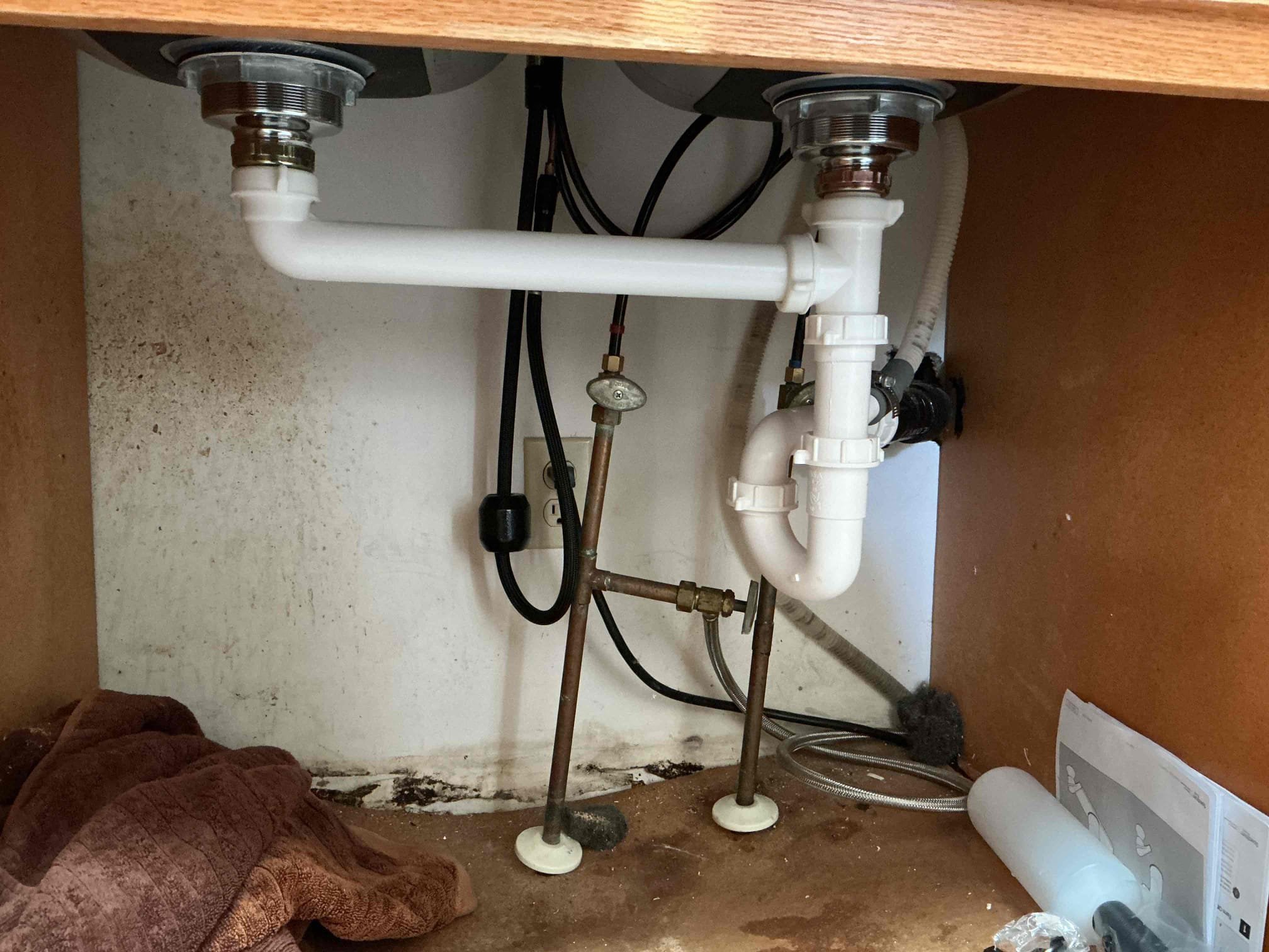 New kitchen faucet supply lines connected under a sink in an Eagan home
