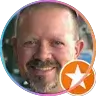 Man with goatee smiling, circular review badge with star icon overlay.