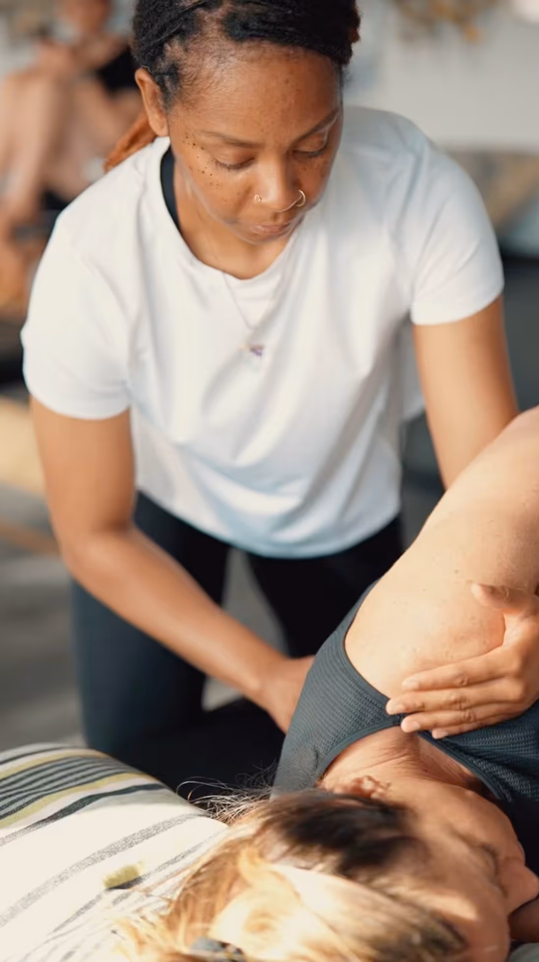 Massage therapist treating patient on massage table with focused care