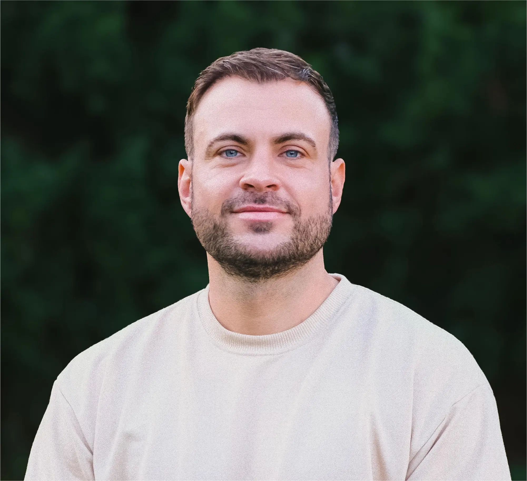 Jan-Paul Jeromin, ein Psychologischer Berater, steht vor einem weißen Hintergrund und trägt ein schwarzes T-Shirt. Er hat dunkle Haare, einen Bart und lächelt. Er trägt ein beiges Hemd.