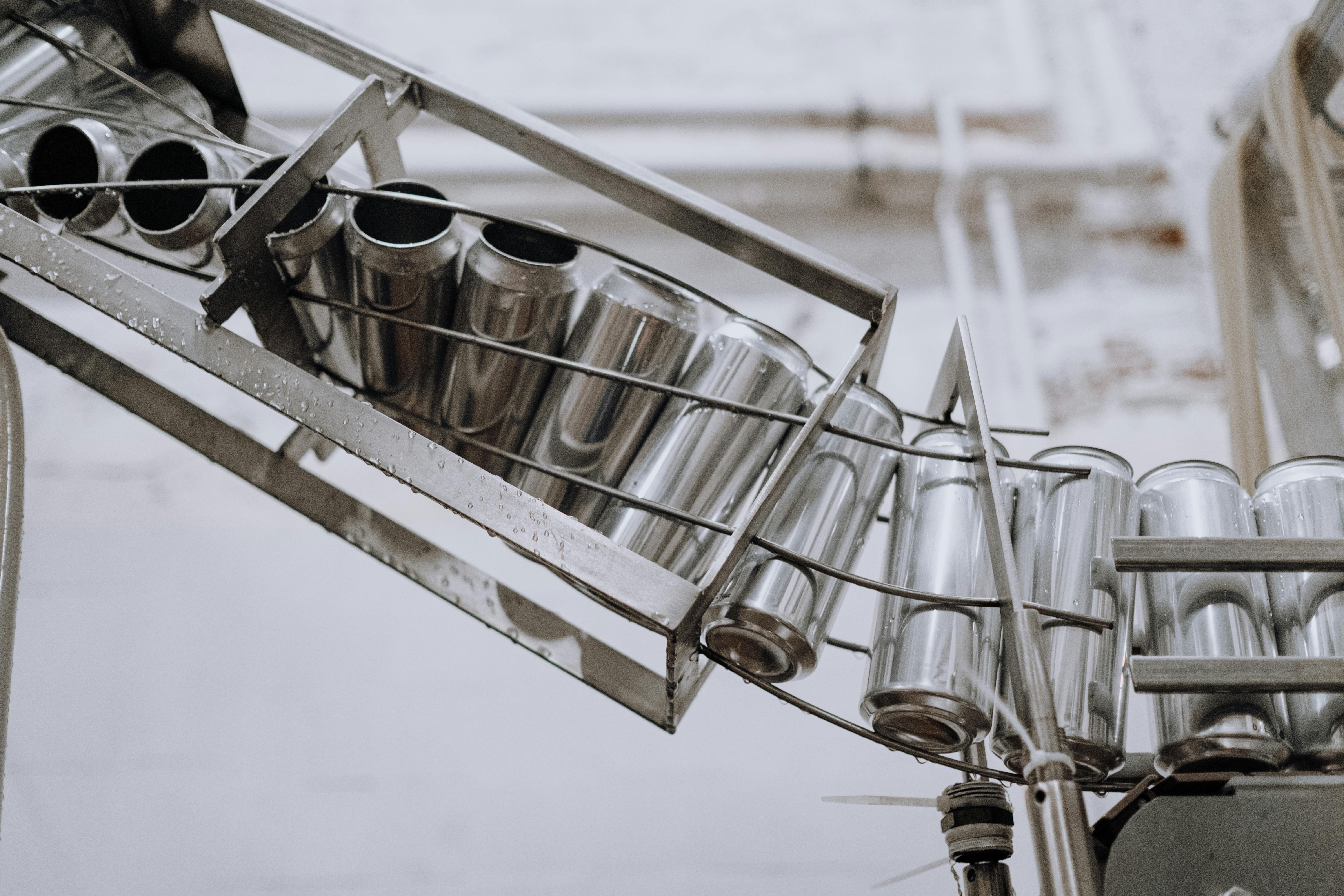 Metal cans lined up on a conveyor belt in a factory setting.