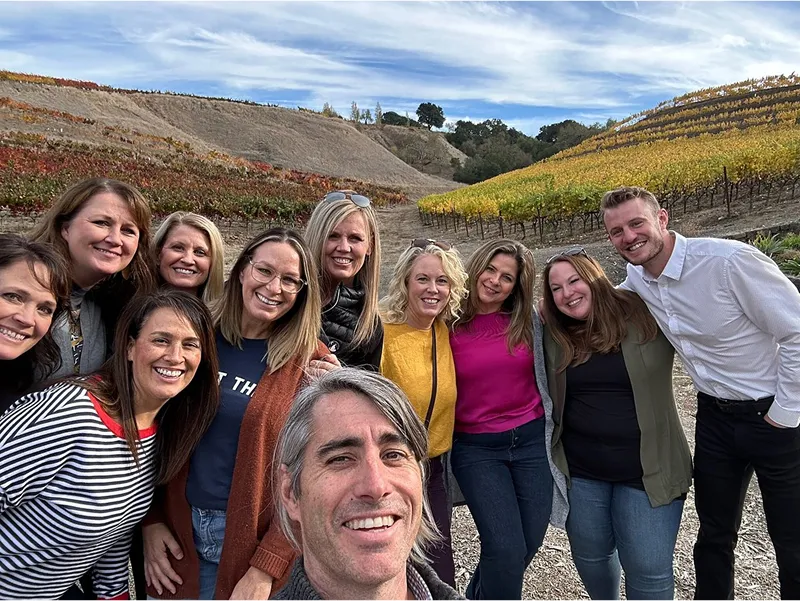 Group of friends enjoying a wine tasting tour in a Napa Valley vineyard
