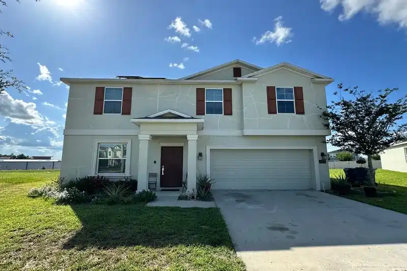 Front of a Florida home before exterior painting, with faded wall color and worn trim.