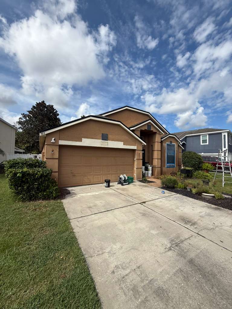 Front of a Florida home before exterior painting, with faded wall color and worn trim.