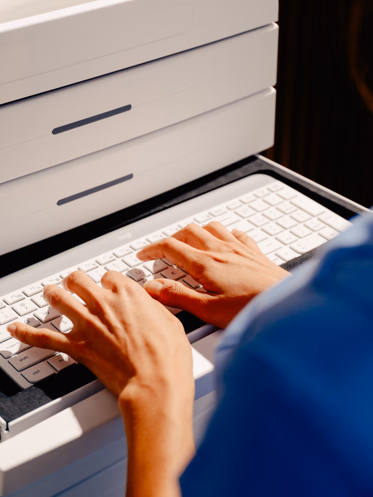Veterinary assistant close up typing in keyboard in a cubex tower cabinet