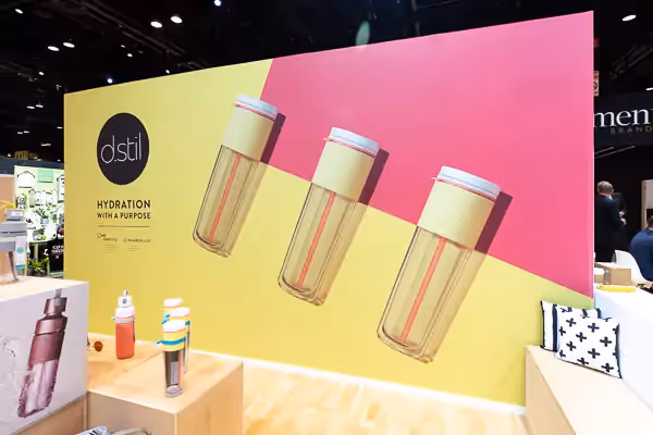 Colorful tradeshow display featuring large wall print of styled product photography.