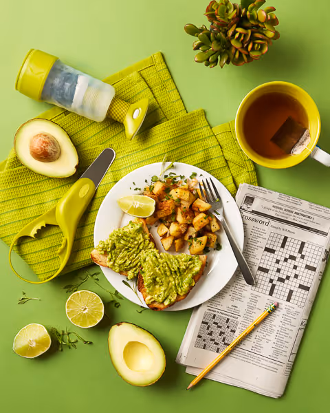 Green monochromatic breakfast scene with avocado toast highlighting a set of avocado tool products.