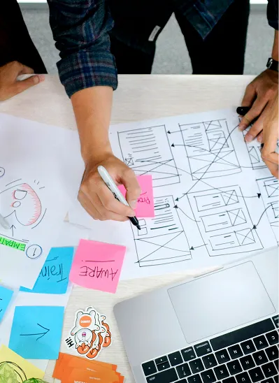 A couple of people sitting at a table with a laptop.