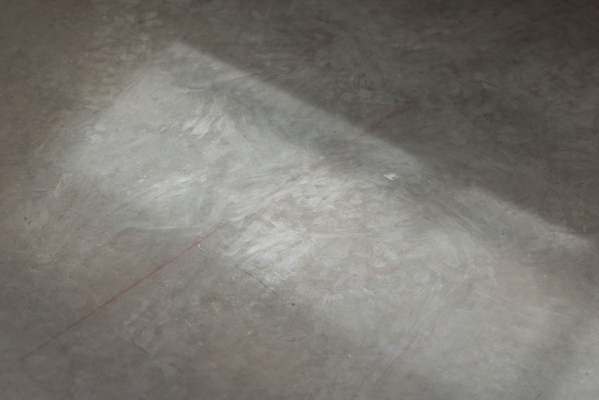 A photo of the raw concrete slab in the sun during construction of a new architect designed home.