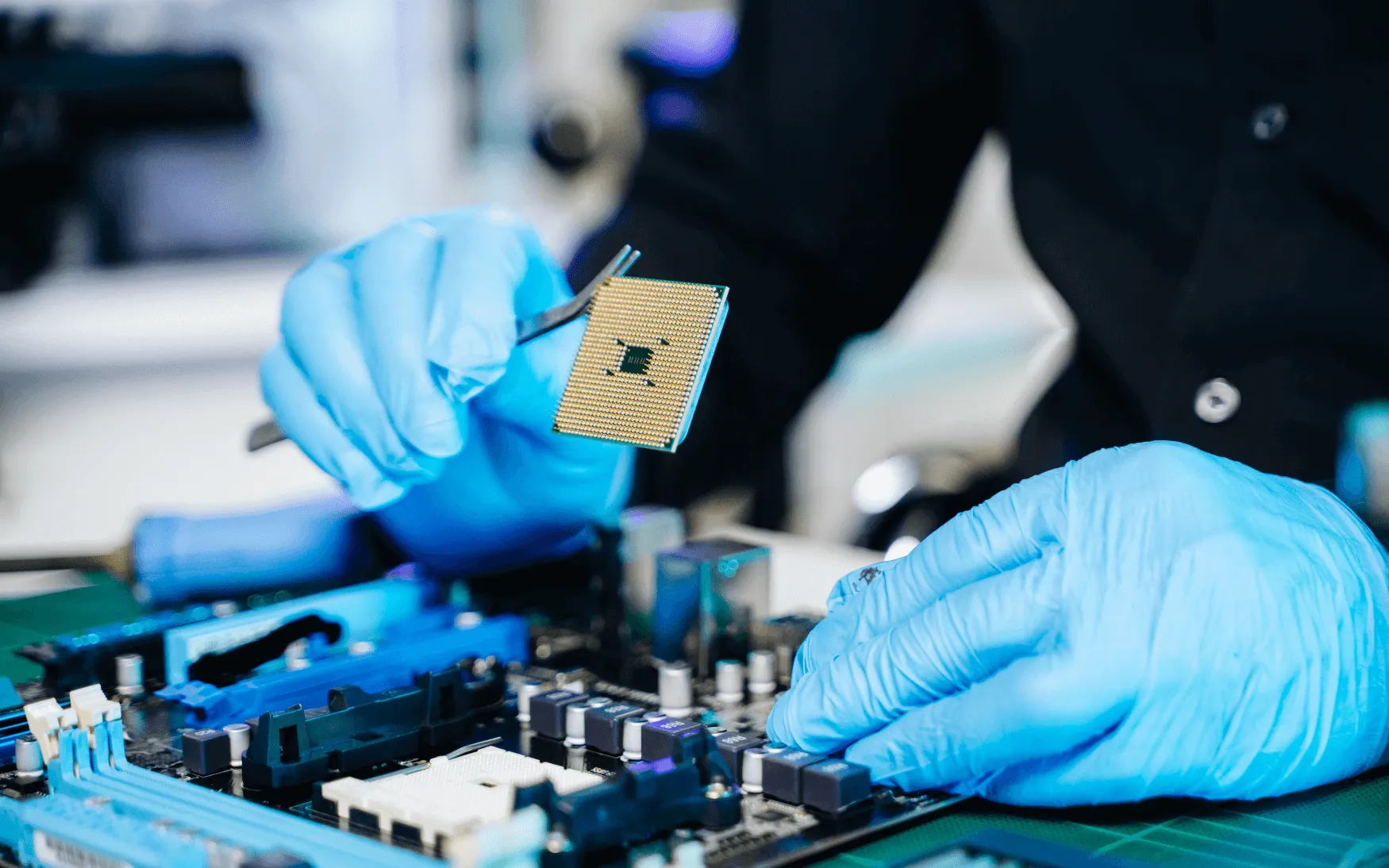Gloved hands soldering a circuit board