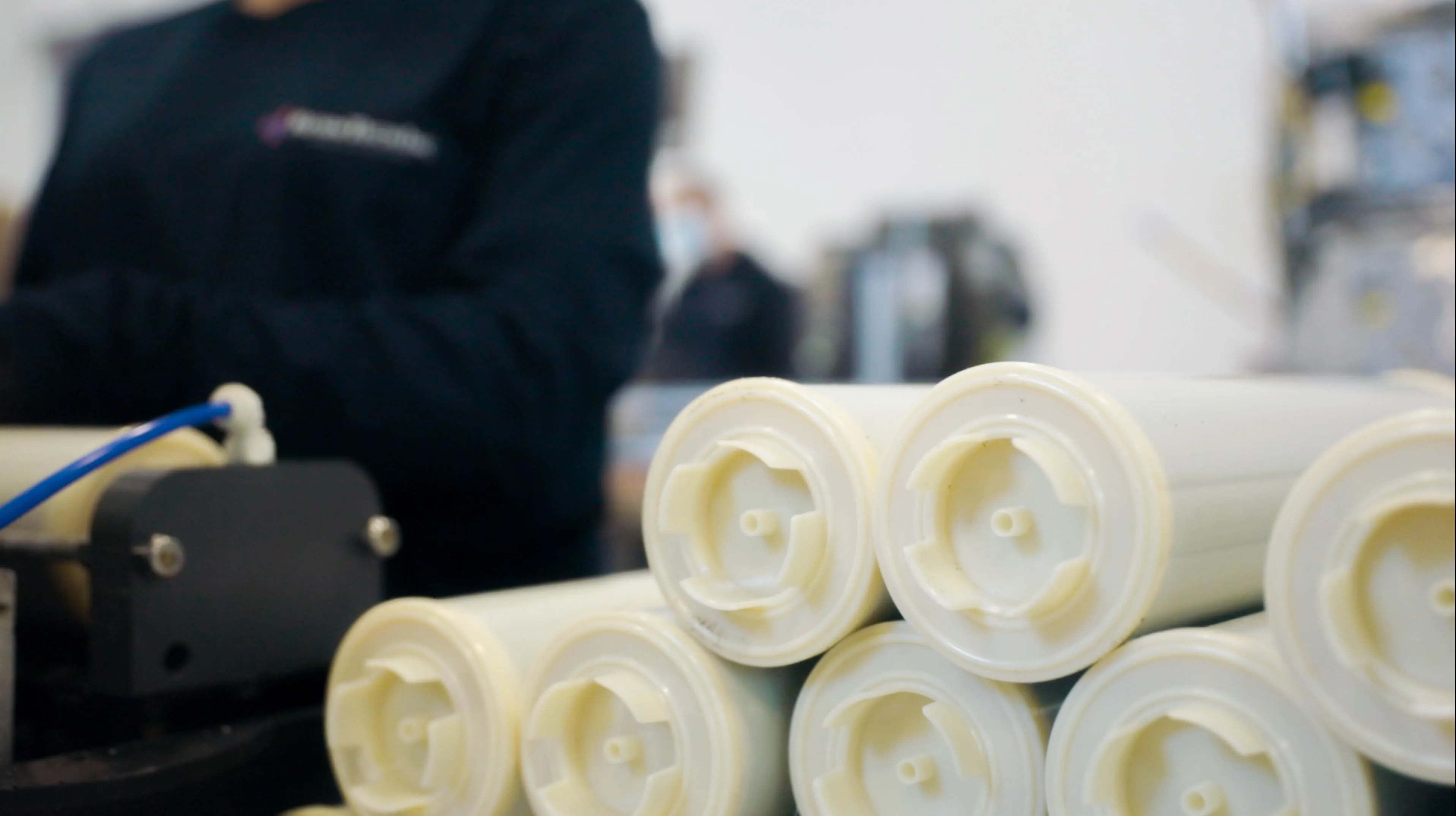 Hands holding white membrane filter cartridges