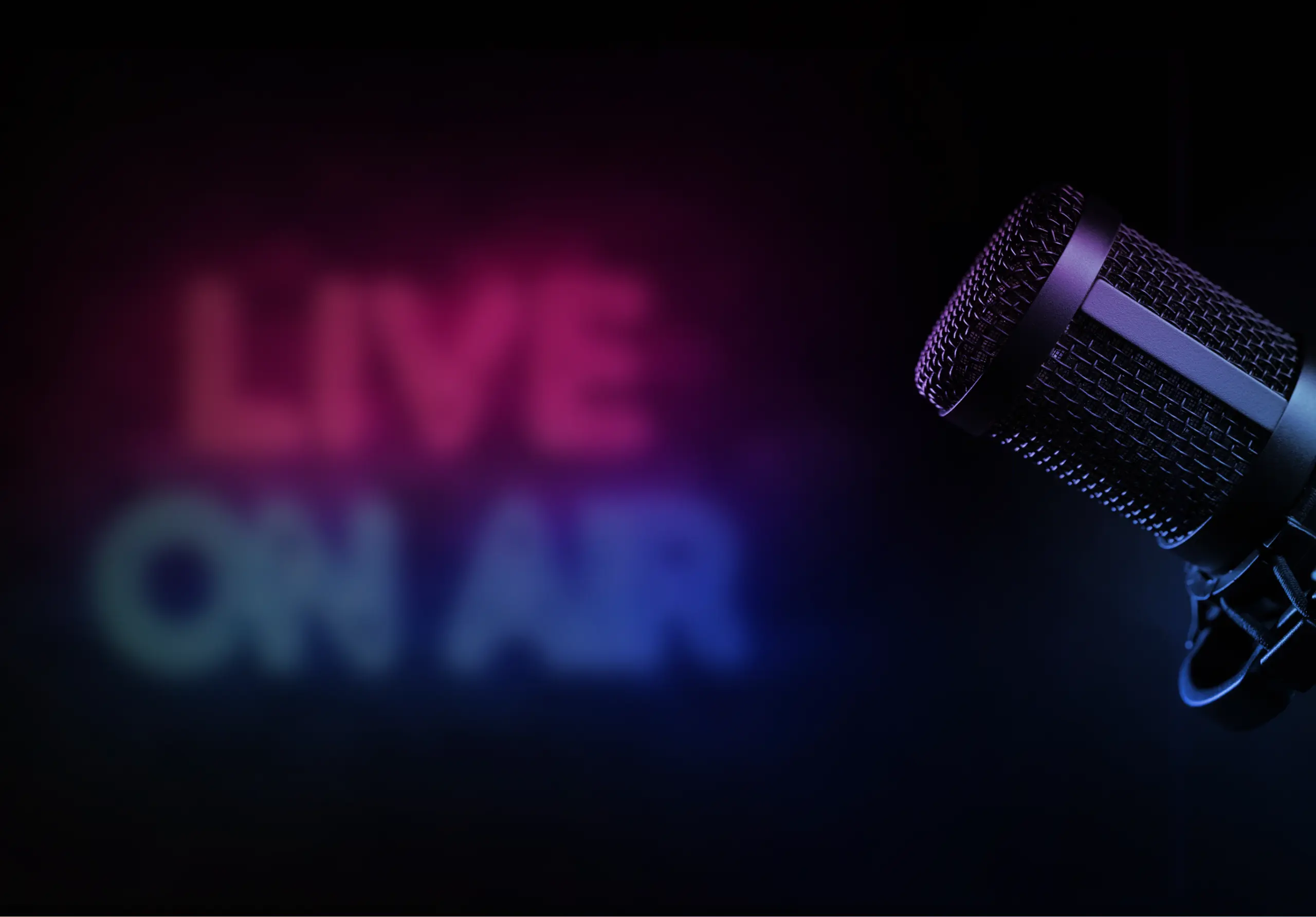 Setup for a live broadcast featuring a professional studio microphone on the right and blurred neon text 'LIVE ON AIR' in red and blue on the left.
