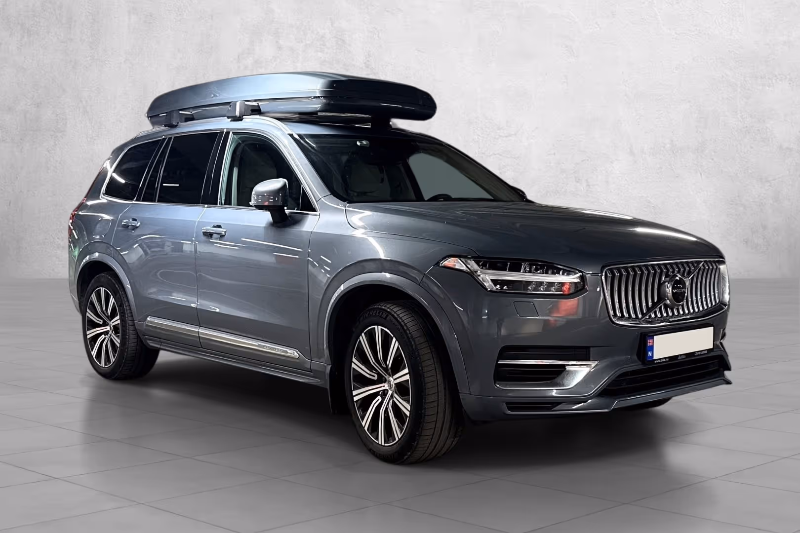 White Volkswagen electric SUV parked indoors against a gray concrete wall.