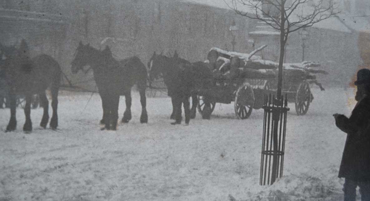 1890 - One of Thomas Armstrong's teams of horses and pole trailer loaded with home-grown timber on a snow covered Main Street in Cockermouth.