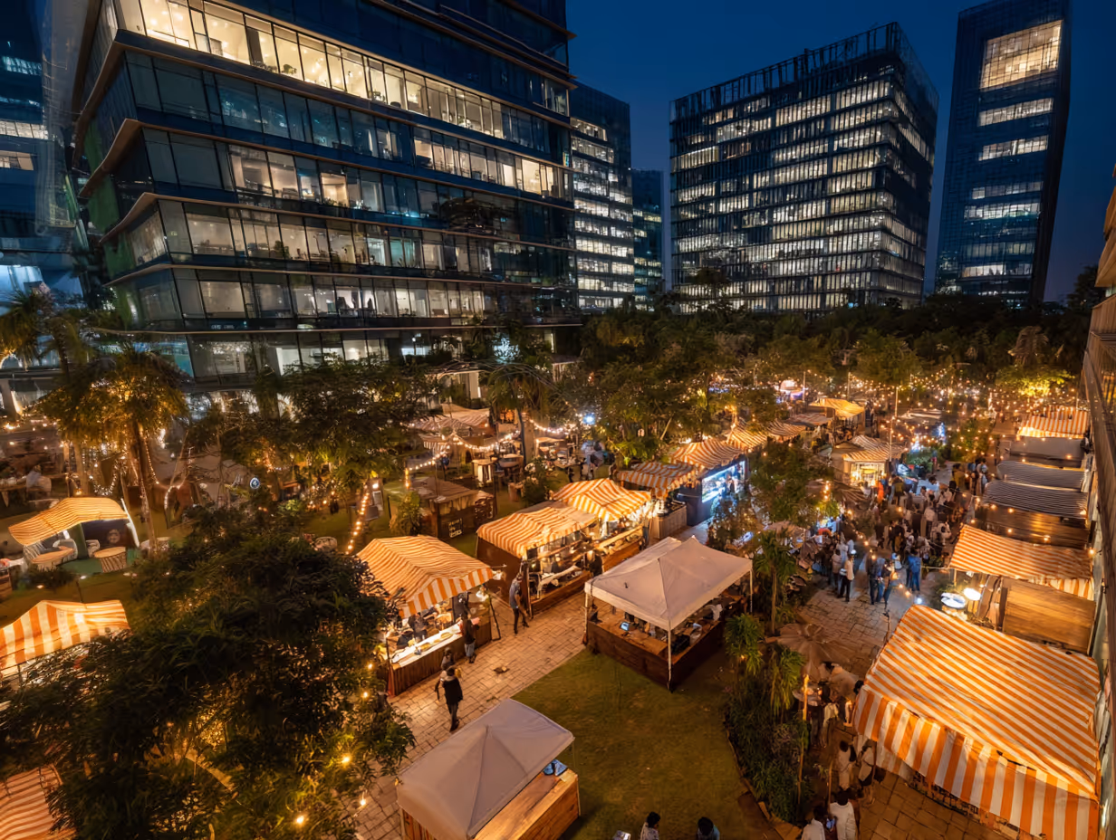Corporate outdoor dining space at dusk with vibrant food court and tented seating areas.