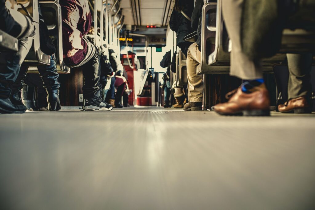 low angled photo of people on the bus from the middle of the aisle perspective.
