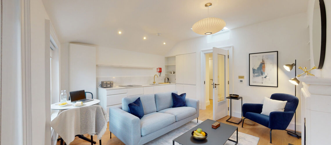 Modern open-plan living space with sleek kitchen, cozy seating, and minimalist decor.