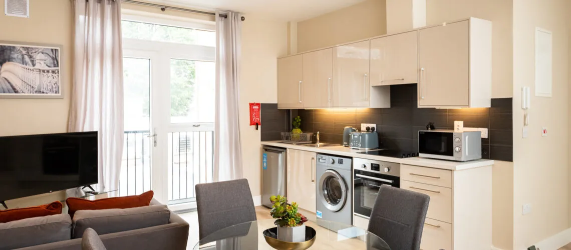 Modern open-plan kitchen and living area with neutral tones and contemporary furnishings.