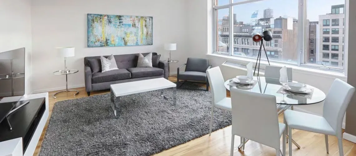 Modern living room with city views, featuring sleek furniture and neutral tones.