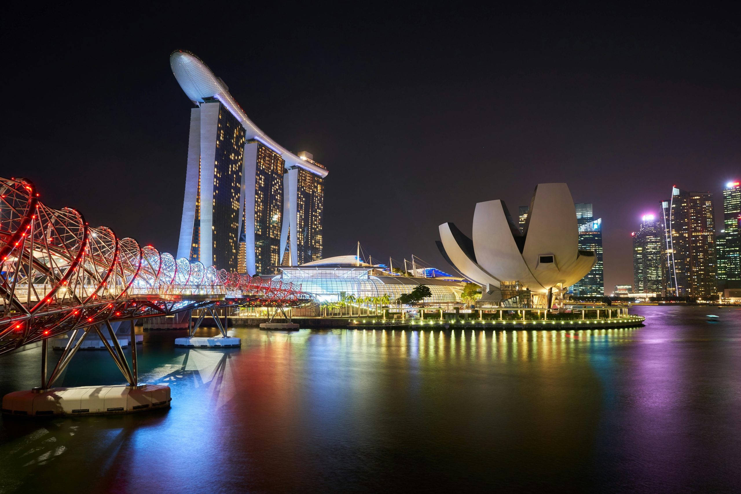 Marina Bay Sands, Helix Bridge, and ArtScience Museum illuminated at night in Singapore.