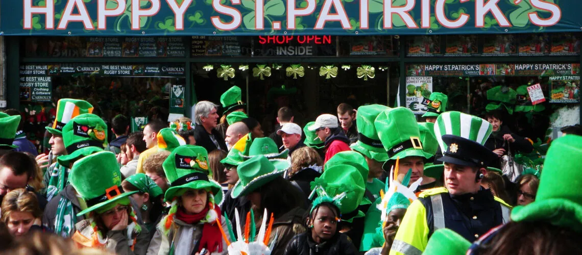 A festive crowd celebrates St. Patrick's Day, adorned with green hats and Irish-themed accessories.