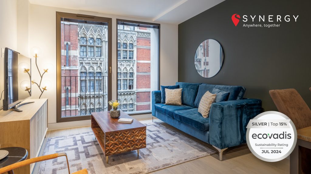 Modern living room with elegant decor, large windows, and EcoVadis Silver sustainability badge.