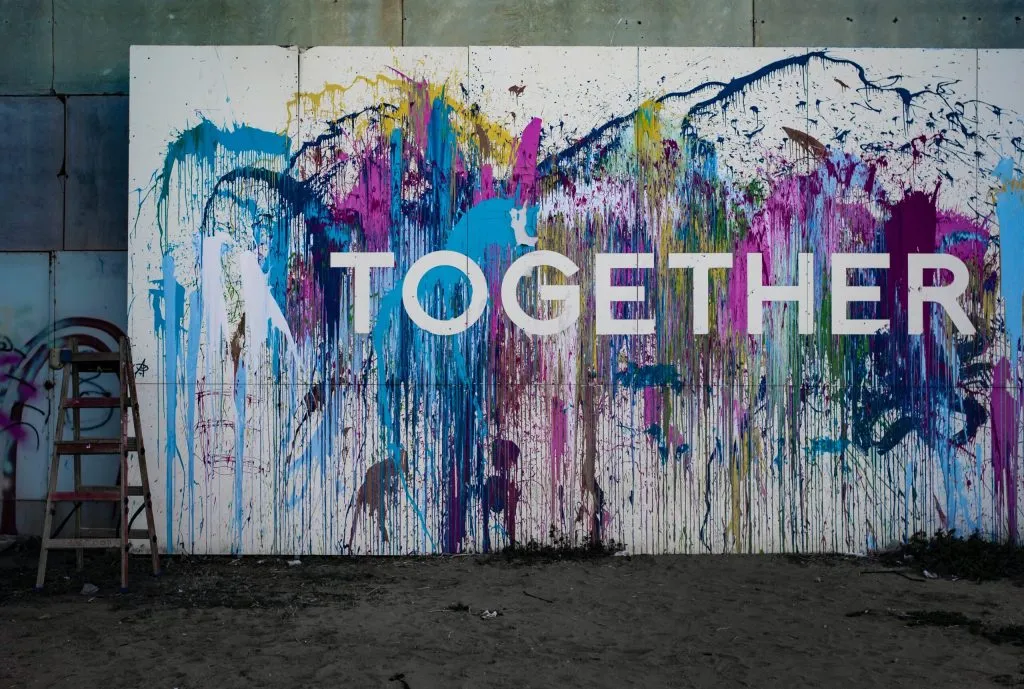 Colorful paint splatters surround the word 