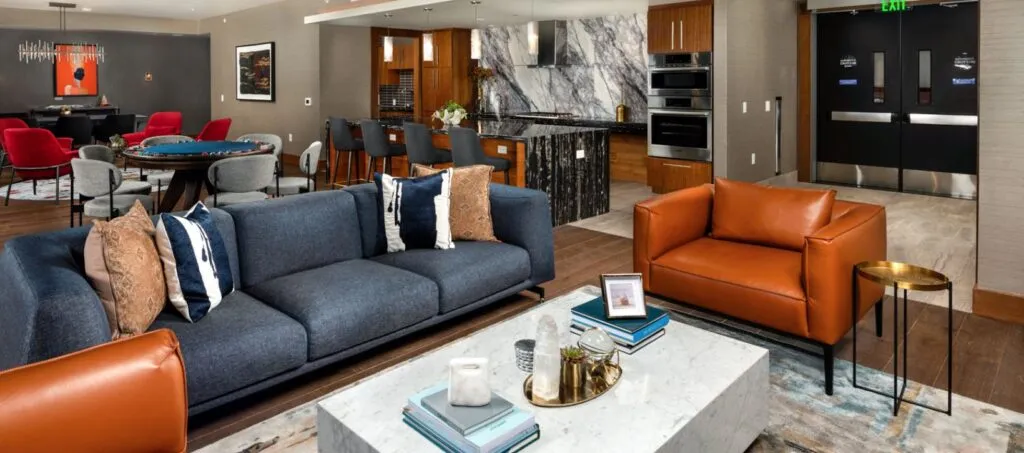 Modern lounge with sleek furniture, open kitchen, and vibrant accents in a sophisticated setting.
