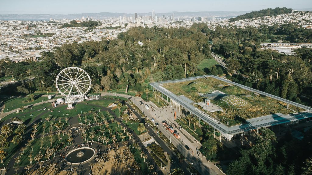 Aerial view of Golden Gate Park featuring a Ferris wheel and the California Academy of Sciences.