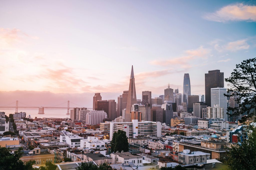 San Francisco skyline at sunset, featuring the Transamerica Pyramid and Bay Bridge in the background.