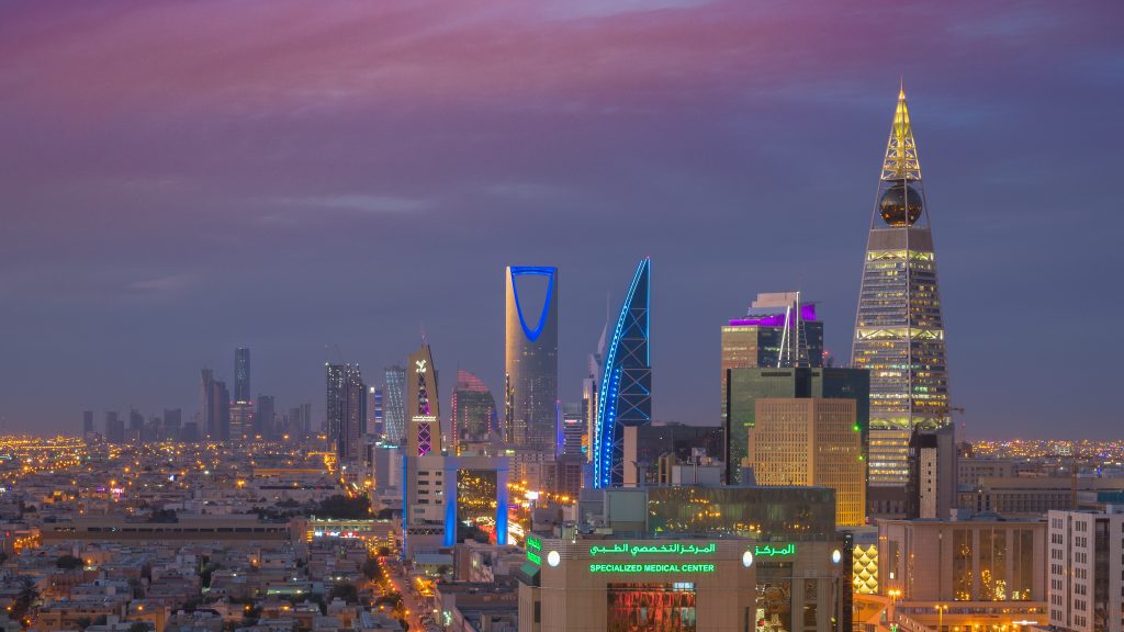 Riyadh skyline at dusk, featuring iconic modern skyscrapers and vibrant city lights.