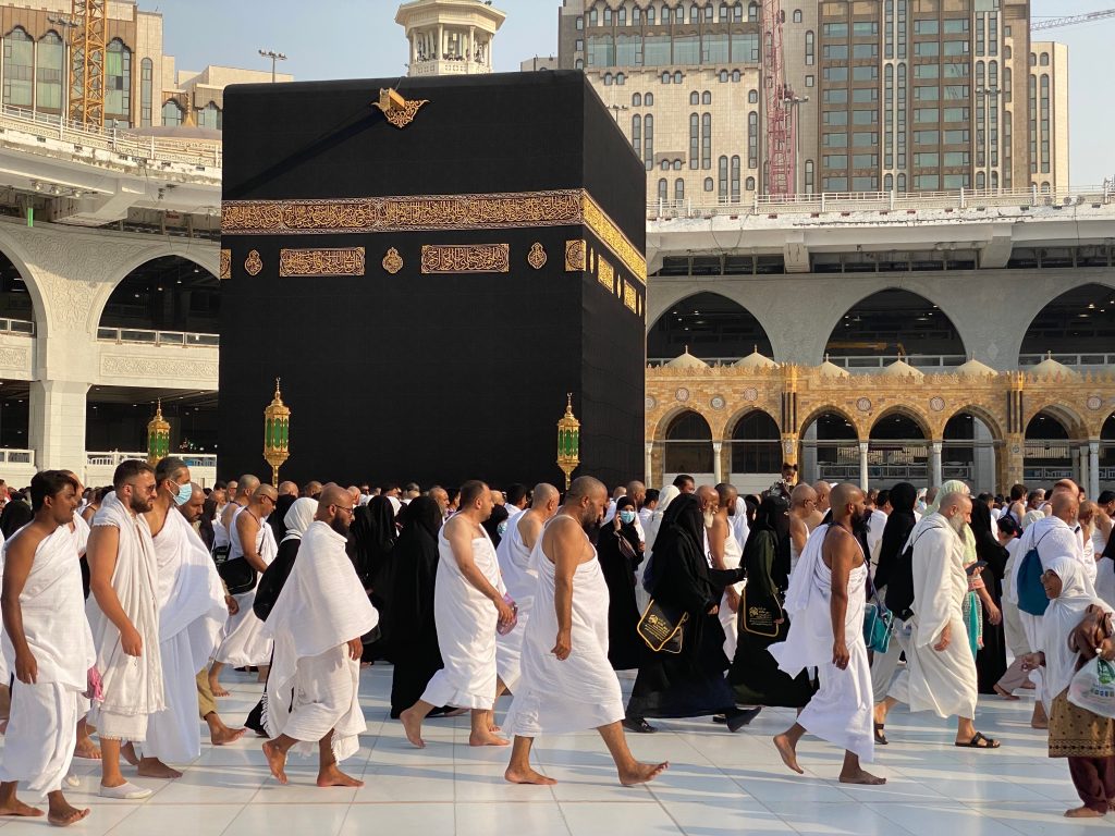 Pilgrims in white Ihram garments perform Tawaf around the Kaaba in Masjid al-Haram, Mecca.