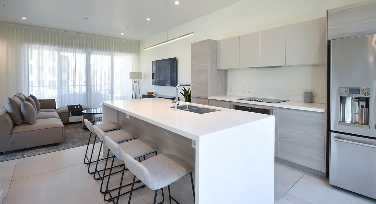 Modern open-concept kitchen and living area with neutral tones and sleek, minimalist design.