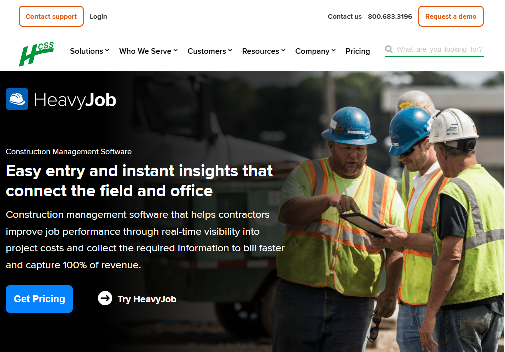 Screenshot of the HCSS HeavyJob homepage promoting its construction management software for contractors, featuring messaging about connecting field and office teams with real-time job cost visibility alongside construction workers reviewing information on a tablet at a jobsite.