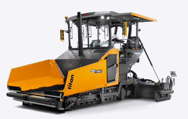 Front three-quarter view of an Ammann ABG 7820 tracked asphalt paver in yellow and gray, shown on a white background.