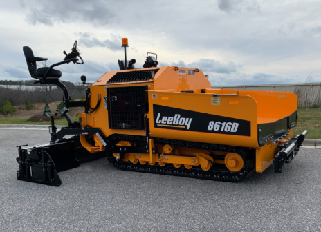 Side view of a LeeBoy 8616D tracked asphalt paver in orange and black, parked outdoors under a cloudy sky.